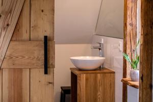 a bathroom with a white bowl sink on a wooden cabinet at Alte Schule Grambow - Lütt Slaapsteed in Grambow