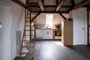 a kitchen with a wooden ladder in a room at Alte Schule Grambow - Lütt Slaapsteed in Grambow +17 photos
