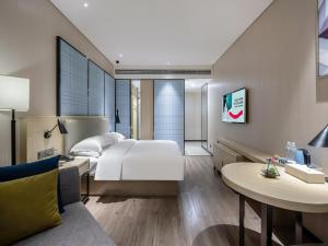 a hotel room with a bed and a table at Echarm Hotel Nanning the MixC Exhibition Center Metro Station in Nanning