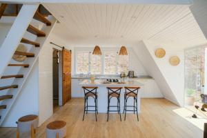 an attic kitchen with a counter and stools at Cabana Branca luxo in Teresópolis +22 photos