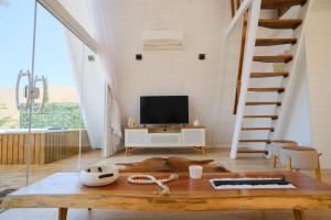 a living room with a staircase and a television at Cabana Branca luxo in Teresópolis