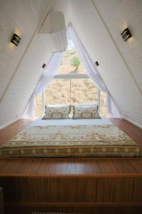 a bed in a room with a window at Cabana Branca luxo in Teresópolis