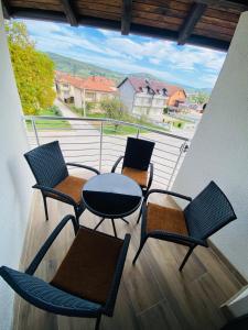 a balcony with three chairs and a table on a balcony at Luxury Pyramid Apartment Visoko in Visoko