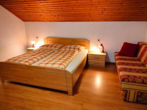 a bedroom with a large bed and a couch at Huberhof Abendsonne in Terento