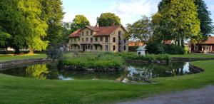 a large house with a pond in front of it at Mössebergs vandrarhem in Falköping