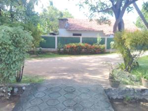 a driveway in front of a house with flowers at Diana's place in Negombo