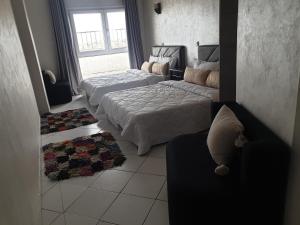 1 dormitorio con 2 camas, sofá y ventana en Beach apartment down town, en Agadir