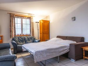 a bedroom with a bed and a couch and chairs at Apartment La Tour d'Antheme by Interhome in Champéry +31 photos