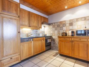 a kitchen with wooden cabinets and a sink at Apartment La Tour d'Antheme by Interhome in Champéry