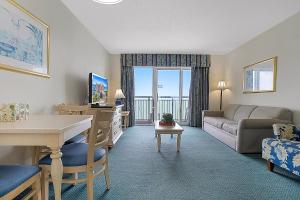a living room with a couch and a table at Bay Watch Resort | Oceanfront | King Suite | Budget Friendly in Myrtle Beach
