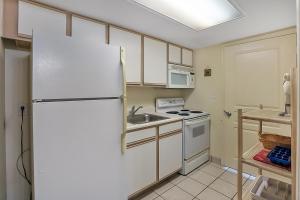 a kitchen with a refrigerator and a sink at Bay Watch Resort | Oceanfront | King Suite | Budget Friendly in Myrtle Beach