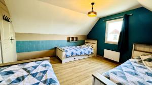 una camera da letto con due letti e una finestra di Cottage Blue Birdie a Cucq