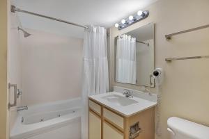 a bathroom with a sink and a toilet and a mirror at Bay Watch Resort | Oceanfront | King Suite | Budget Friendly in Myrtle Beach +15 photos