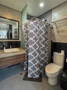 a bathroom with a toilet and a shower curtain at Siargao Bed and Brewery in General Luna +26 photos