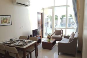 a living room with a table and chairs and a living room at High Ceiling Home by the Pool with Wi-Fi and Netflix in Lapu Lapu City