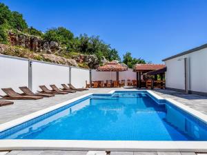 a swimming pool with chairs and a house at Apartment Delfin-4 by Interhome in Cesarica