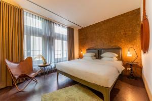 Cette chambre comprend un grand lit et une fenêtre. dans l'établissement Hotel V Nesplein, à Amsterdam