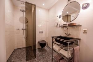 une salle de bain avec un lavabo et une douche dans l'établissement Hotel V Nesplein, à Amsterdam 35 autres photos