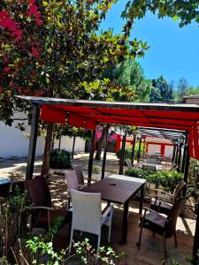 un patio con tavolo e sedie sotto una tenda. di Hotel Color a Asenovgrad