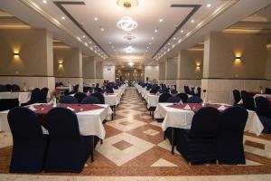 a banquet hall with white tables and chairs at Maysan Al Maqam Hotel in Mecca