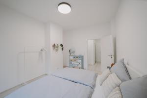 ein weißes Zimmer mit einem Bett und einem Sofa in der Unterkunft Stilvoll&Modern-Nähe DUS und CGN in Wuppertal