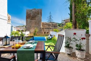 un patio avec une table et des chaises et une piscine dans l'établissement Genteel Home San Nicolas, à Grenade