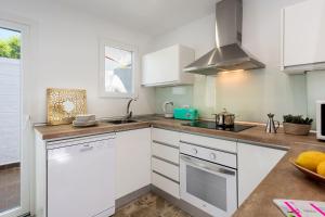 une cuisine avec des armoires blanches et un four à plaques de cuisson dans l'établissement Genteel Home San Nicolas, à Grenade 16 autres photos