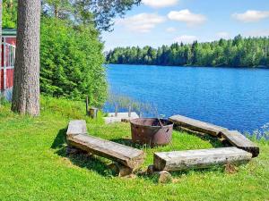 due panchine sull'erba accanto a un lago di Holiday Home Einola by Interhome a Laiska