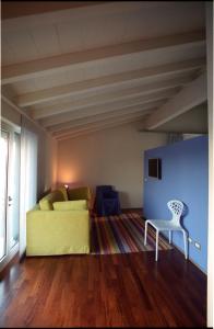 a living room with a yellow couch and a chair at San Marco Holidays in Lucca