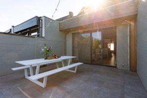una mesa de picnic blanca sentada en un patio en Huswell - House Tilo: A blend of heritage, scenery, and comfort for 8 Guests, en Ypres