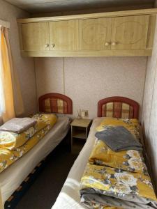 two twin beds in a room with a table at 2 Bedroom caravan Hunstanton pets go free in Hunstanton