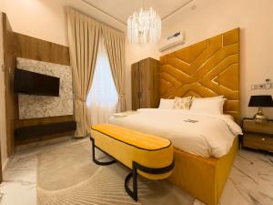 a bedroom with a large bed and a chandelier at Teflon suites Kumasi in Kumasi