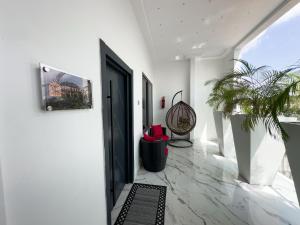 a hallway with a black door and a potted plant at Teflon suites Kumasi in Kumasi