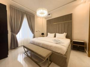 a bedroom with a large bed and a chandelier at Teflon suites Kumasi in Kumasi