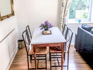 a dining room table and chairs with flowers on it at Holiday Home Oak Cottage by Interhome in Shermanbury +36 photos