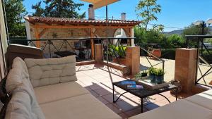 a patio with a couch and a table at Kouklinos Cottage in Koropíon