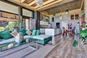 un soggiorno con un divano verde e una cucina di Zephyr Luxe Apartment Sea and Mountain View a Città di Rodi
