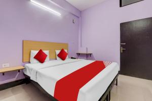 HasanganjHotel O SRV Palace的卧室里有一张大床，配有红色枕头 更多23张照片