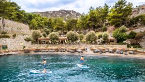 dos personas en tablas de surf en el agua en Z-Villas Beach Hotel, en Turunç