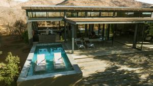 a house with a swimming pool and a patio at Umoya Safari Lodge in Matlhagame