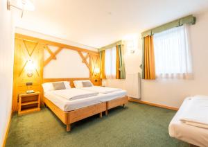 Postel nebo postele na pokoji v ubytování Alpine Mugon Hotel