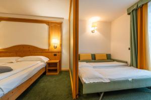 Postel nebo postele na pokoji v ubytování Alpine Mugon Hotel