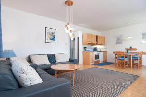 a living room with a blue couch and a table at Haus Bergblick in Faak am See