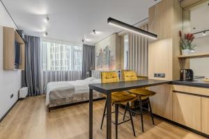 a room with a bed and a kitchen with a table at Manhattan High Line Apart in Kyiv +43 photos