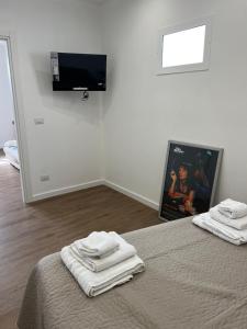 une chambre avec un lit et une télévision à écran plat dans l'établissement Scilia casa vacanza, à Palerme