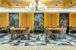 restauracja ze stołami, krzesłami i obrazami na ścianach w obiekcie Hotel Maria & Spa w mieście Szczawnica