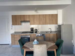 a kitchen with a table with chairs and a refrigerator at Studio Meuble a 5 min de l'aéroport Casablanca in Nouaceur