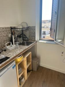 une cuisine avec un évier et une fenêtre dans l'établissement Scilia casa vacanza, à Palerme