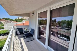 a balcony with sliding glass doors with a table and chairs at Apartment Matea in Duće