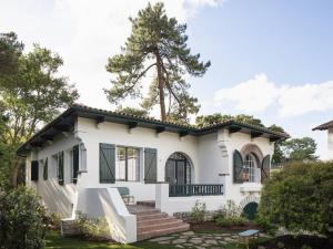 a white house with a tree in the background at Villa de luxe avec piscine au cœur de Hossegor, proche golf, plage et lac - FR-1-791-9 in Soorts-Hossegor